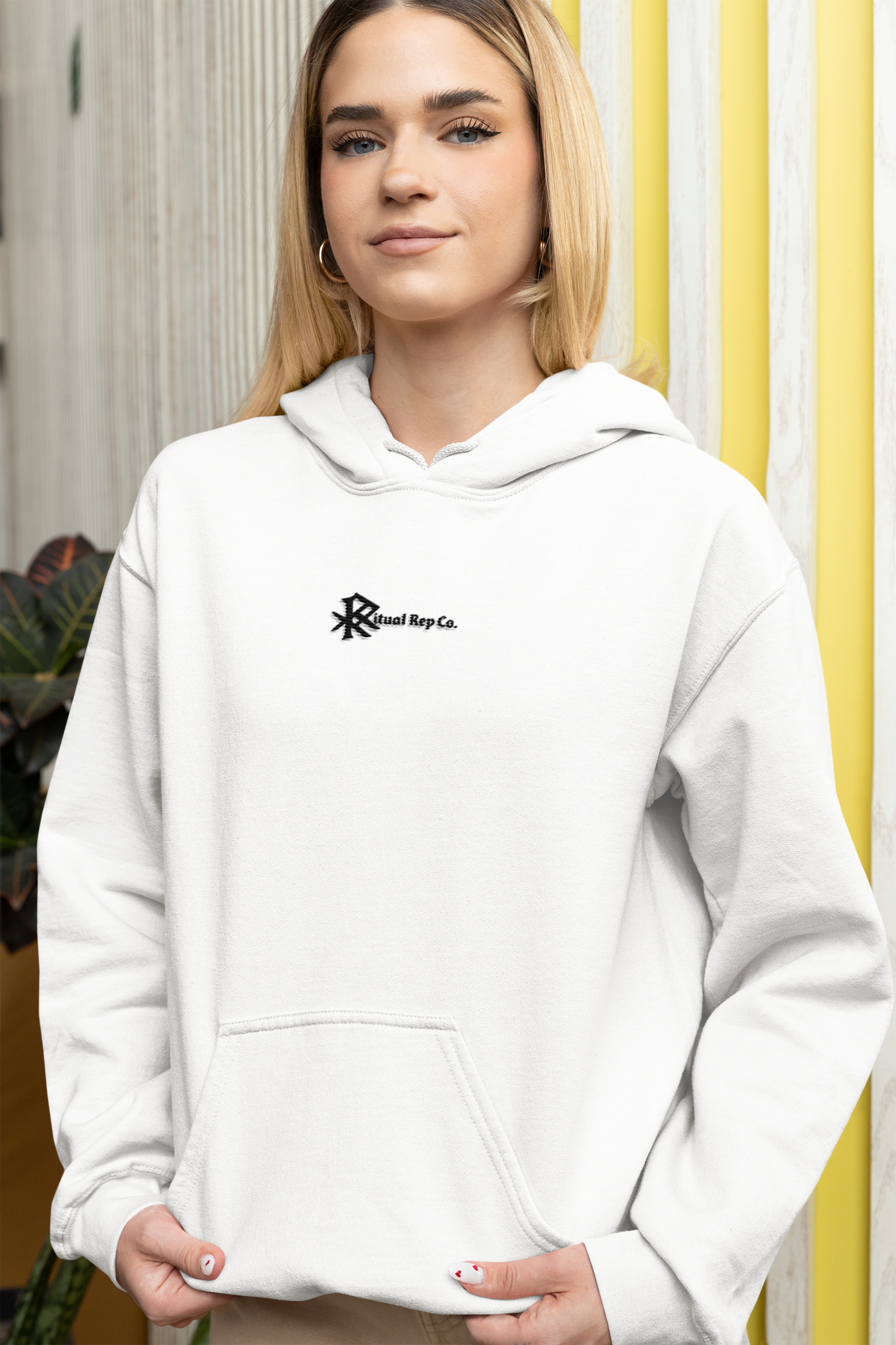 Model wearing white Initiate Hoodie in soft indoor light—Ritual emblem over heart in focus.